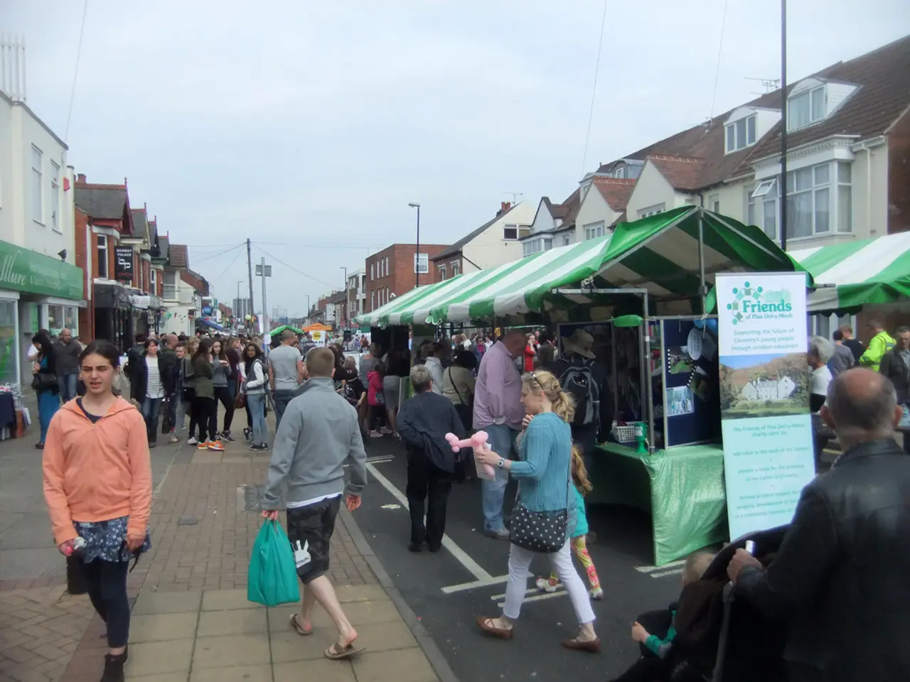 Here some people are standing and some are waking, these are houses, this is sky.