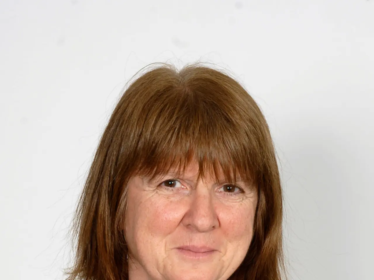 In this image we can see a women with brown hair wearing black coat and white t shirt.