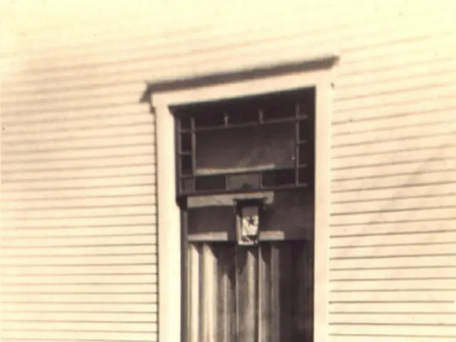 In this image there is a child riding bicycle on the path. In the background there is a building...