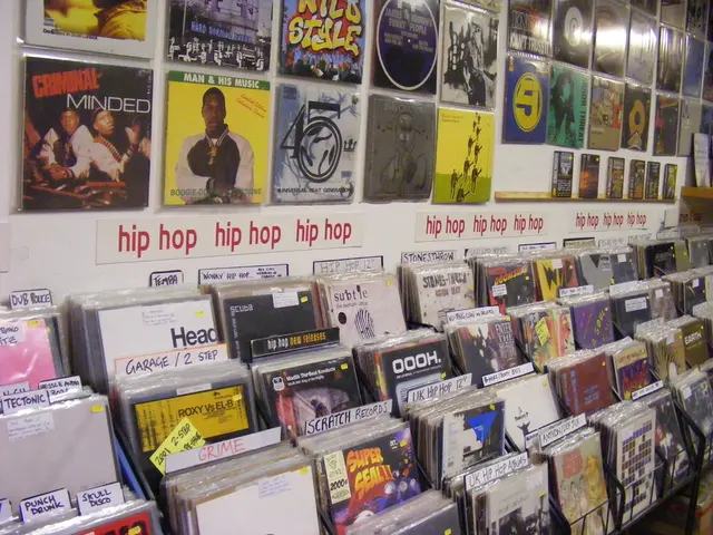 In this image I can see few books and optical disc cases. These are arranged in a metal stand. Many...