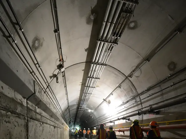 This is the inside view of a tunnel where we can see pipes, light and people walking on the...