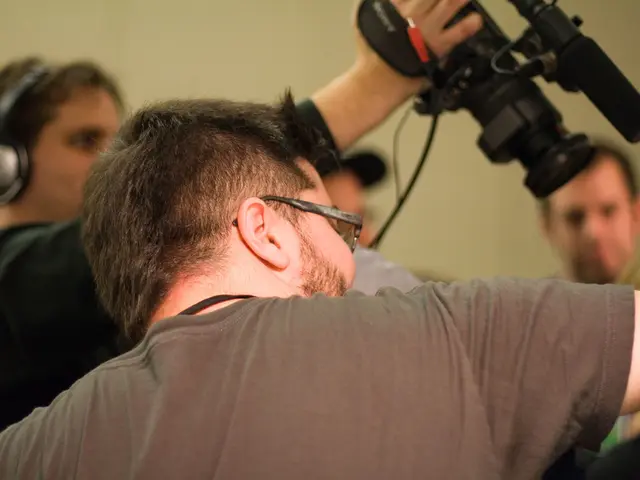 In this picture there is a man wearing spectacles was standing and there is another man in the...