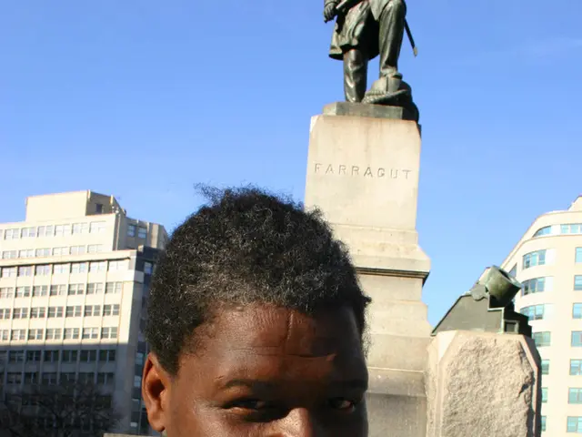 In this image there is a man standing. He is smiling. Behind him there are sculptures on the...