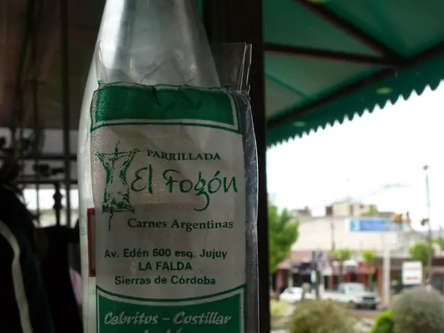 In this picture there is a bottle on the table. On the bottle there is a label with text on it....